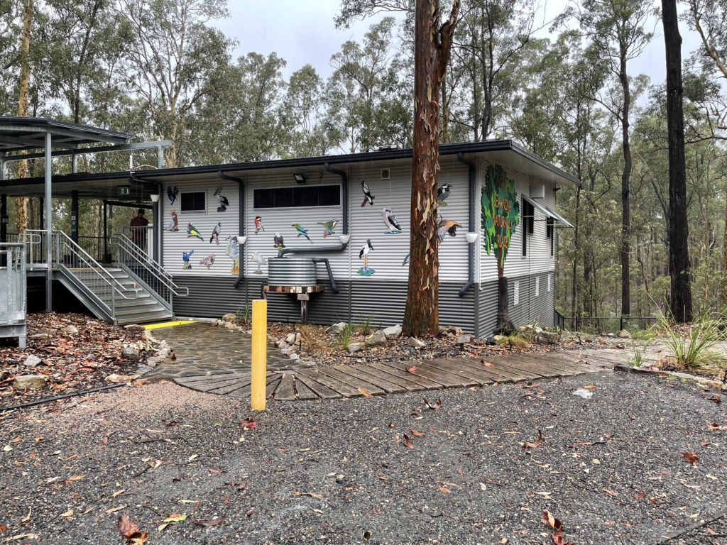 building in the bush with different types of birds decorated on it