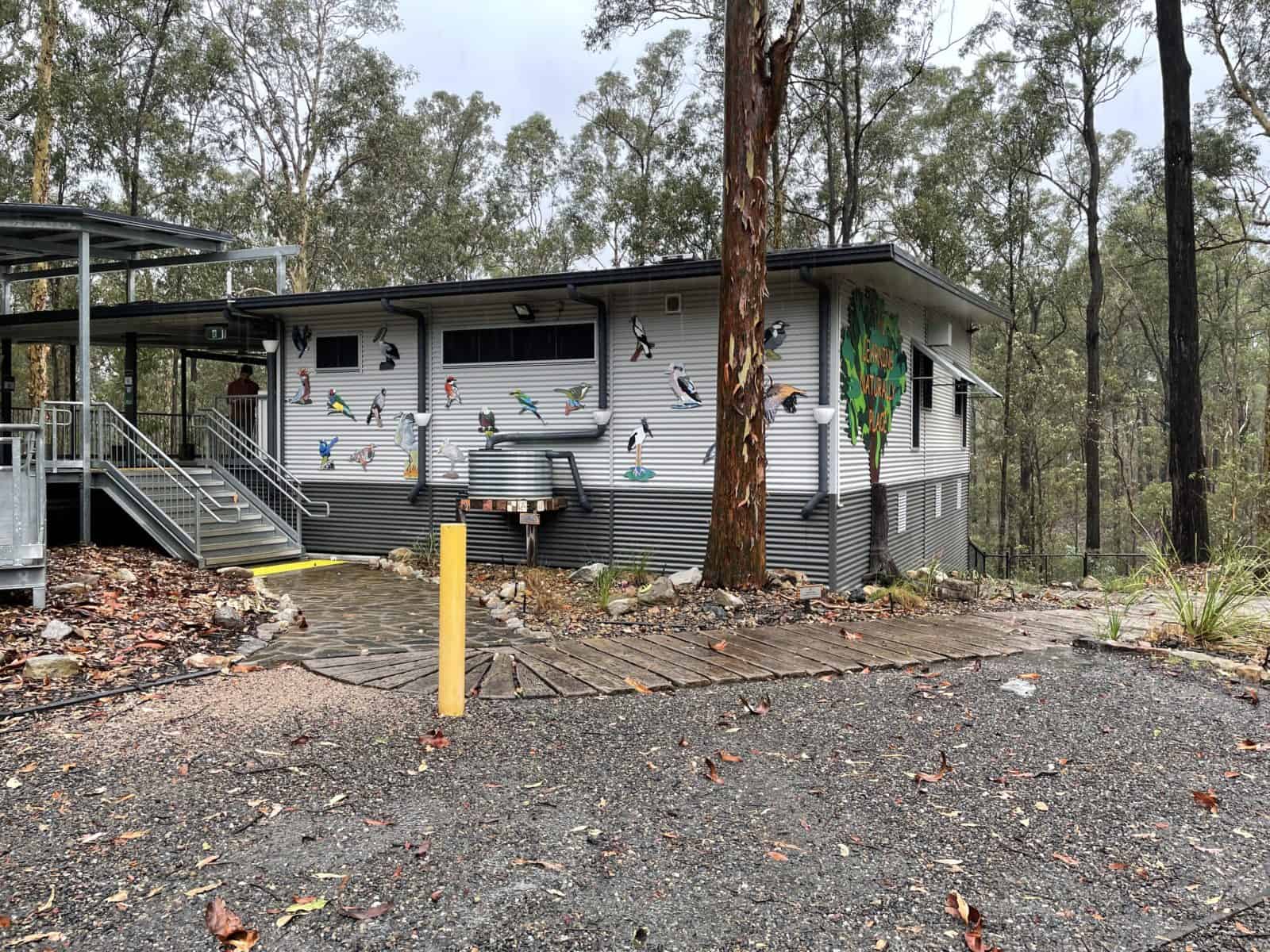 building in the bush with different types of birds decorated on it